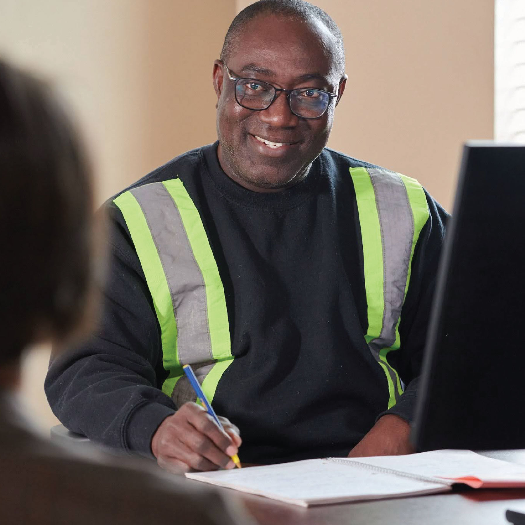 Homme assis derrière un ordinateur souriant